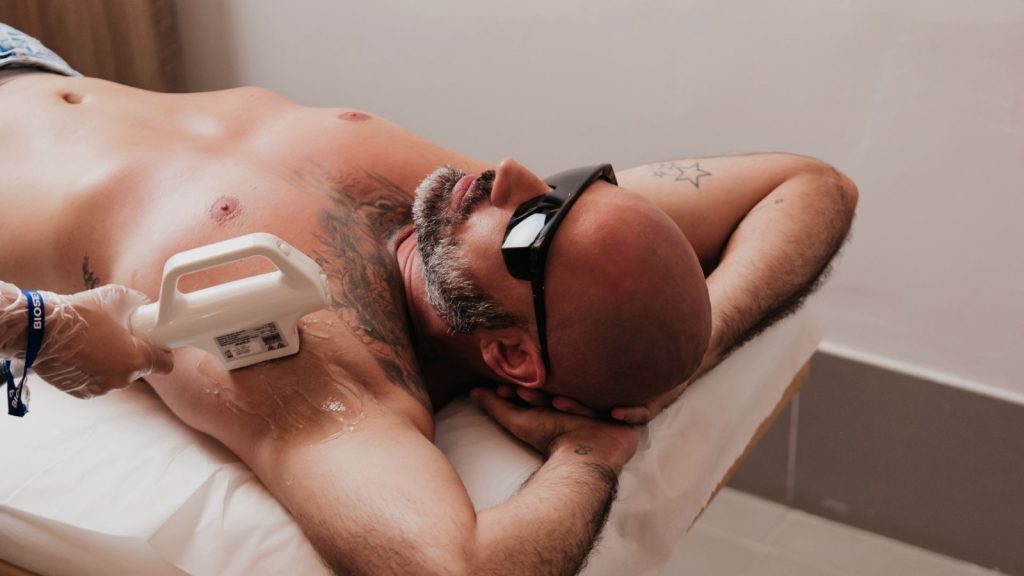 Homem com óculos de proteção durante sessão de luz pulsada no peito